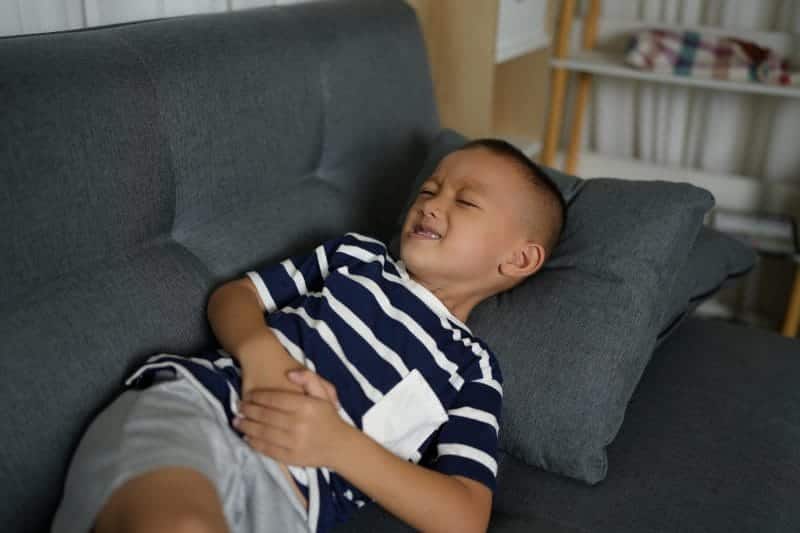 asian boy has stomach pain from food poisoning