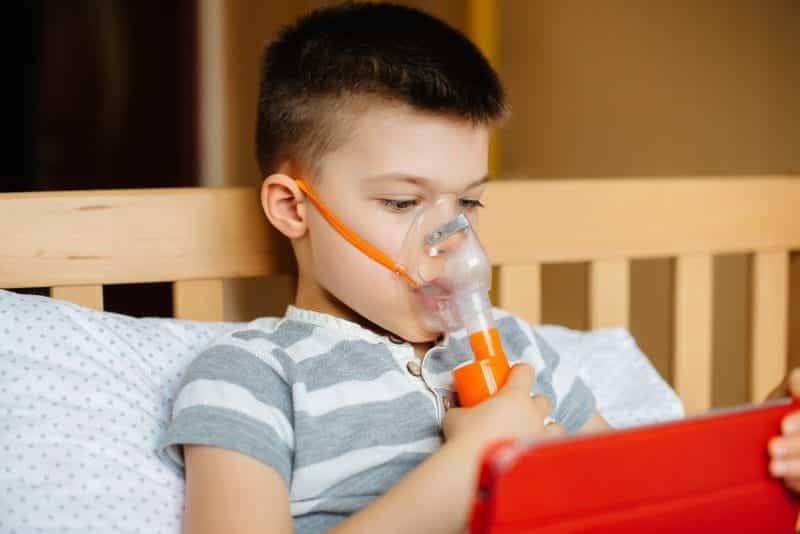 boy plays tablet lung inhalation procedure covid19 coronavirus pandemic