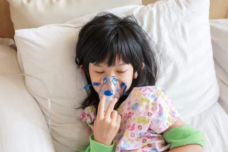 sick little asian girl inhalation with nebulizer respiratory treatment 1